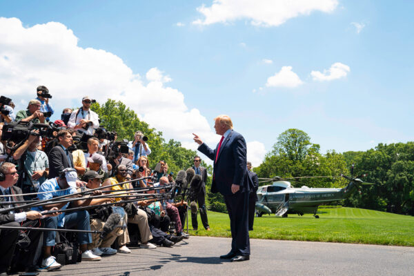 Trump erhebt den Zeigefinger vor einer Gruppe Journalisten